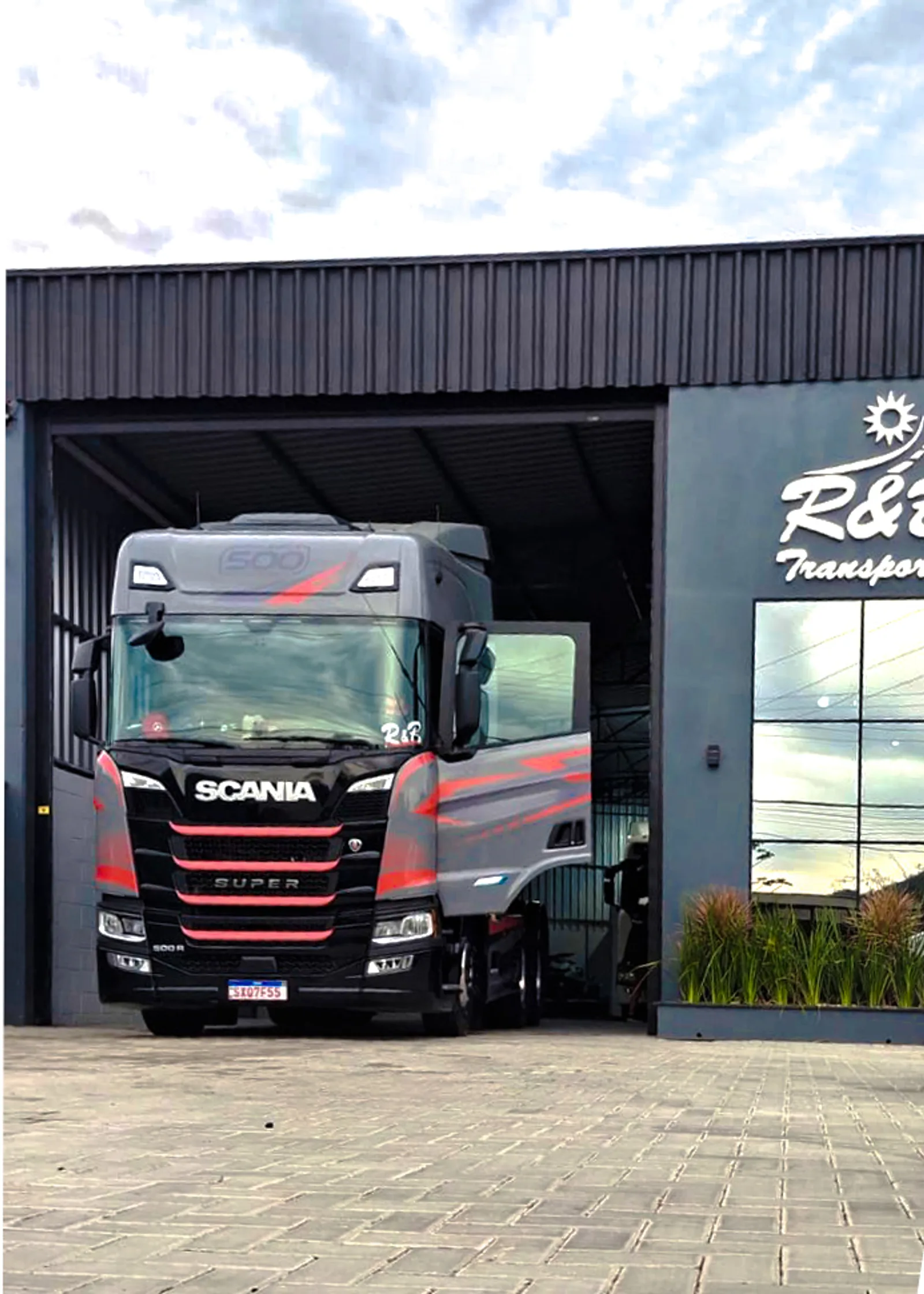 Caminhão da R&B Transportes na entrada do galpão da empresa